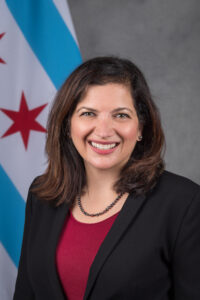 Rachel is smiling in front of the Chicago flag. 
