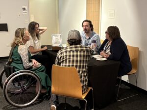 Photo of guests chatting with presenter Craig McNabb at his table.
