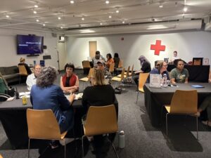 Photo of guests around tables chatting at the LEAD 2026 Share Out.