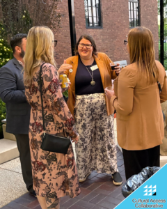 Guests stand with drinks chatting out in the courtyard.